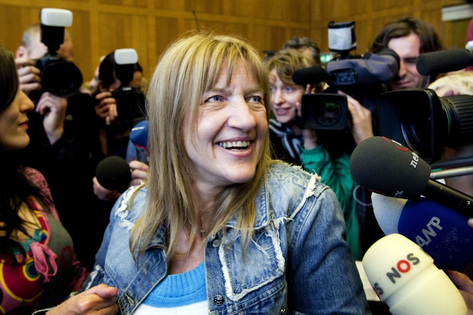 Lucia de Berk, acquitted of murder charges, smiles surrounded by media.