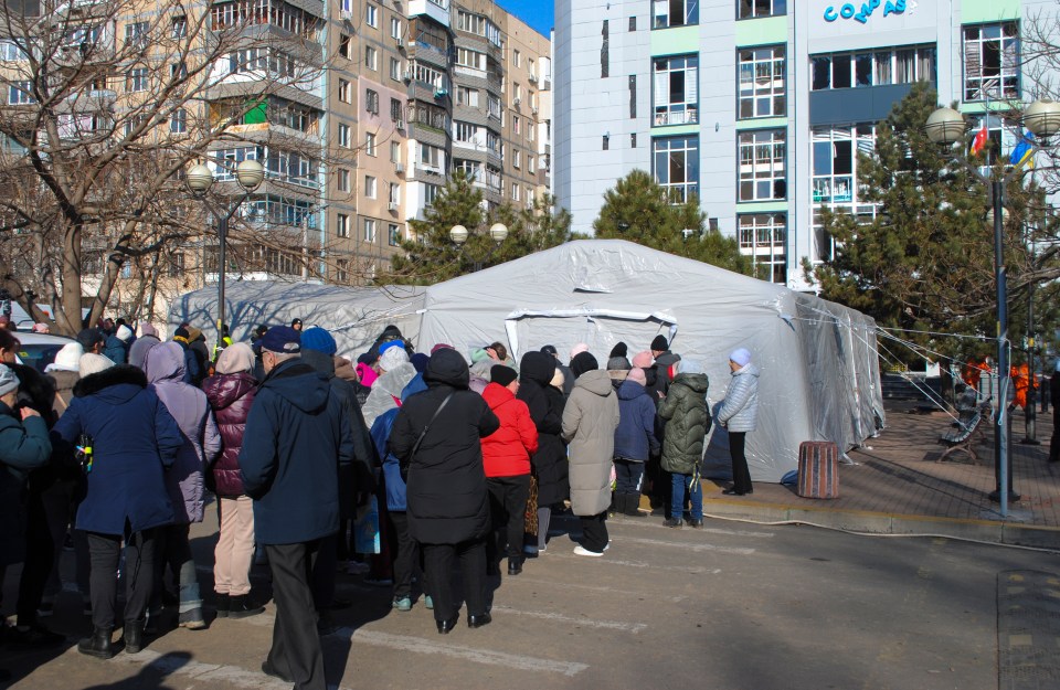 People queueing for humanitarian aid outside a tent in Odesa, Ukraine.