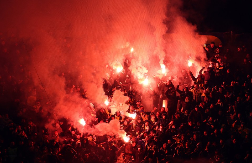 Fenerbahce fans igniting flares in the stands.