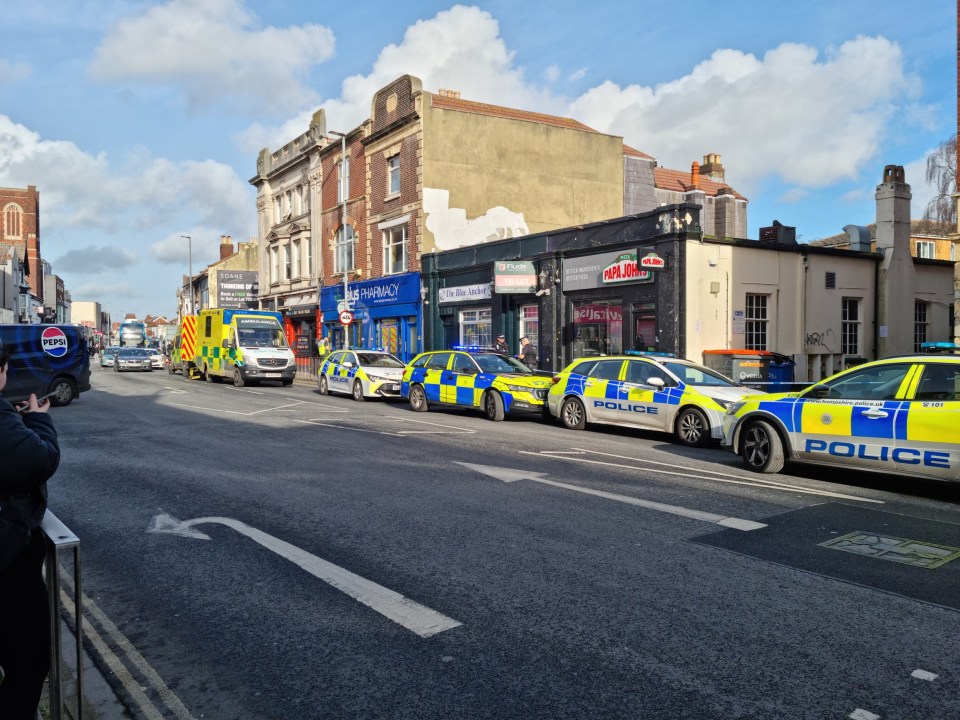 Police cars and an ambulance at a city street scene.