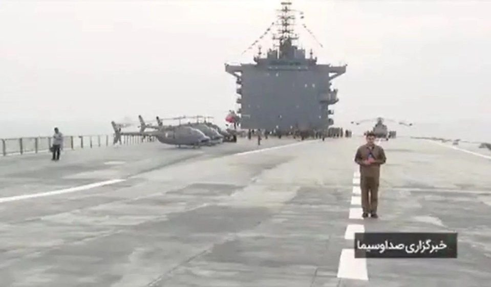 A reporter stands on the deck of the Shahid Bakri drone carrier warship.