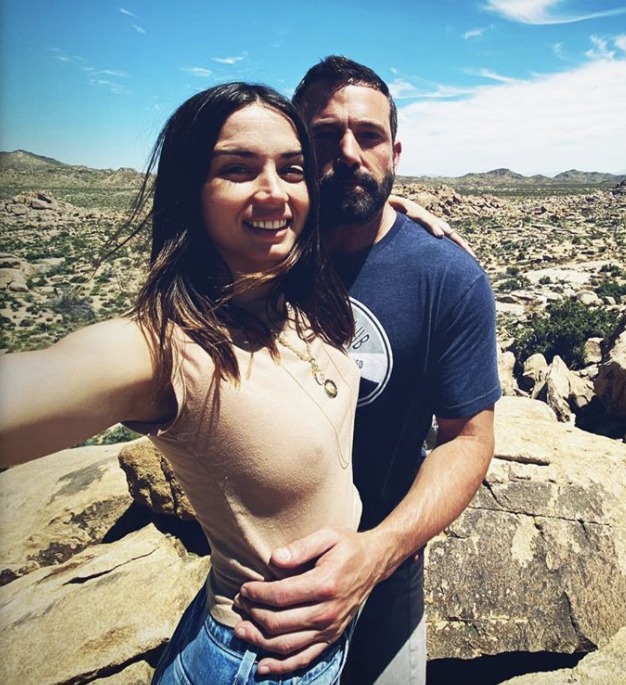 Ana de Armas and Ben Affleck embracing in a rocky landscape.