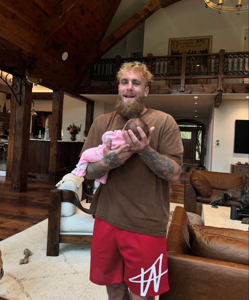 Man holding a baby in a large home.