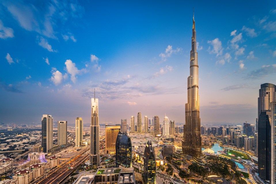 Aerial view of Dubai skyline at sunset.