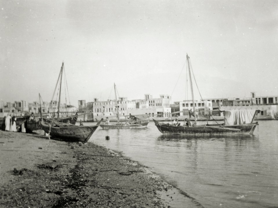 Black and white photo of boats on a river in Dubai.