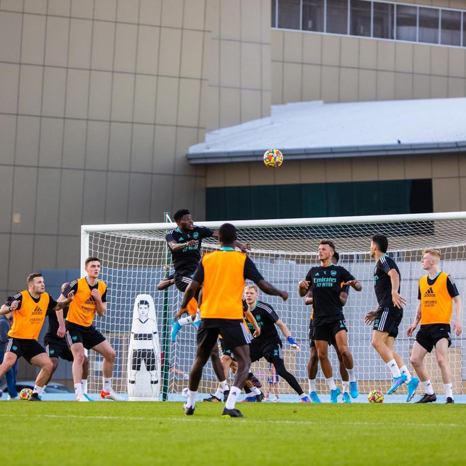Arsenal soccer players practicing heading a ball during training.