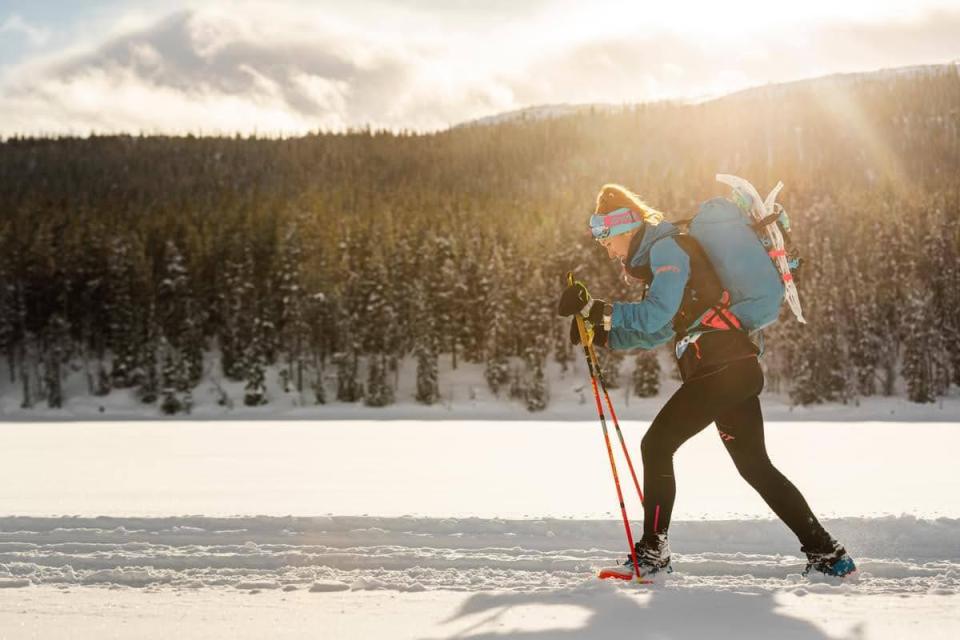 Woman ski touring in snowy landscape.