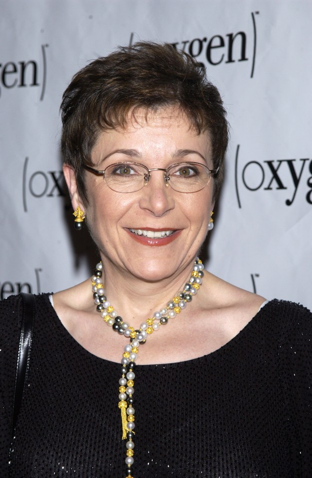 Headshot of Caroline Myss wearing glasses and a pearl necklace.