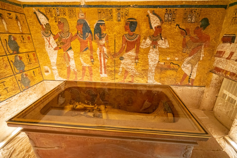 Ancient Egyptian tomb with sarcophagus and wall paintings.