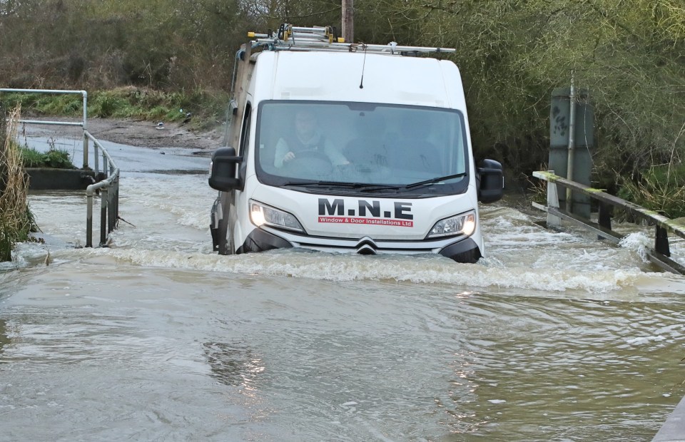Van driving through floodwater.