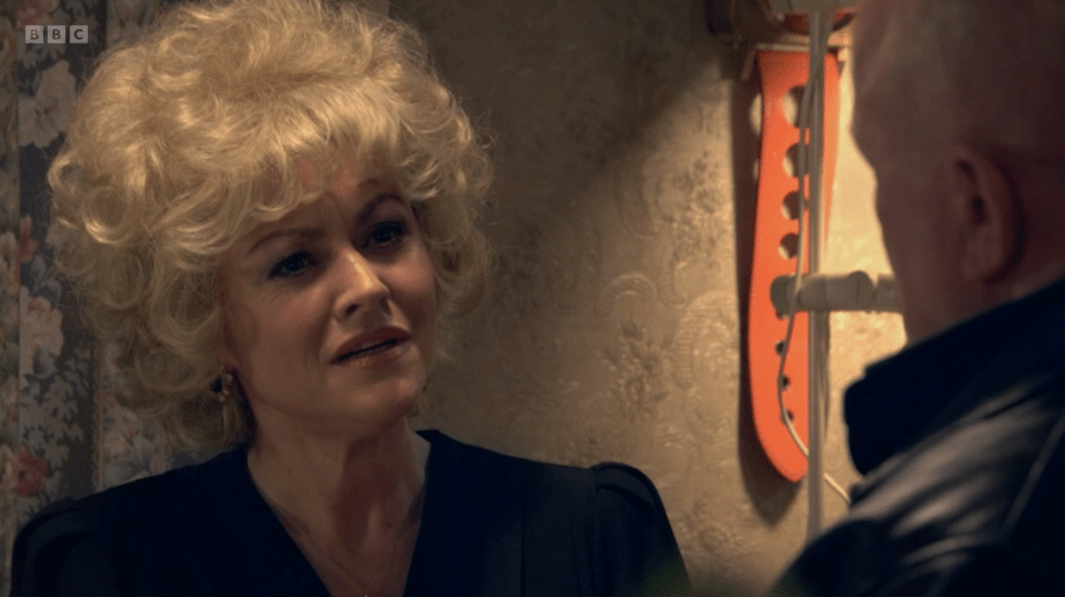 Screenshot of a woman with blonde hair talking to a man.