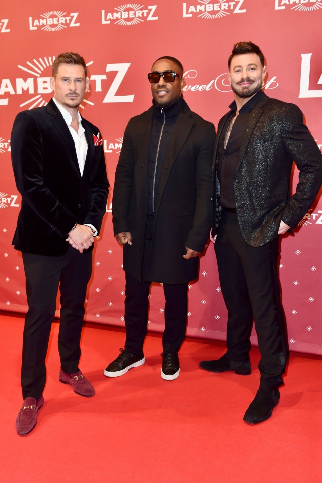 Lee Ryan, Simon Webbe, and Duncan James of Blue on a red carpet.