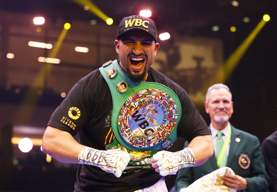 Agit Kabayel celebrating a boxing victory with the WBC Interim World Heavyweight Title belt.