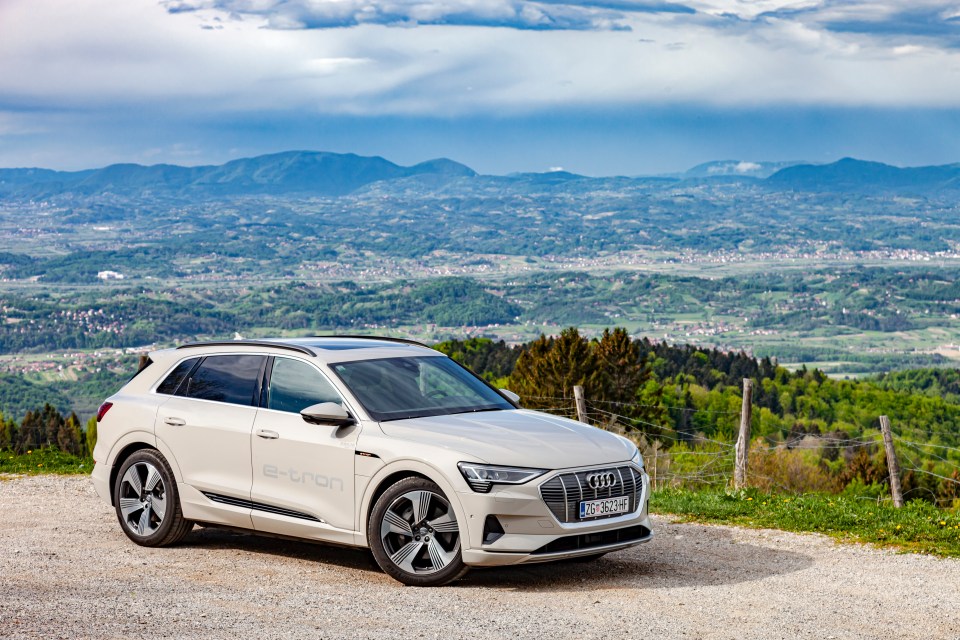 Audi e-tron parked on a road overlooking a valley.