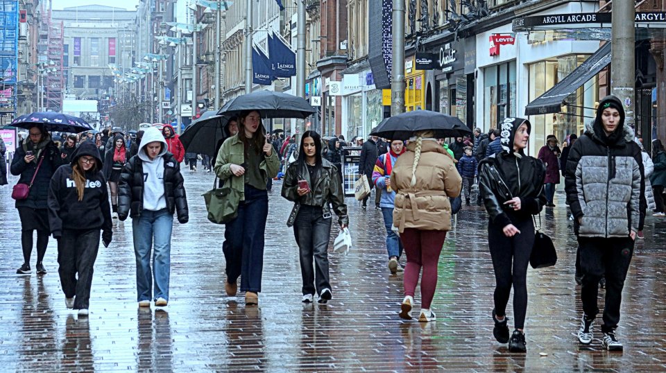 People walking on a rain-slicked city street.