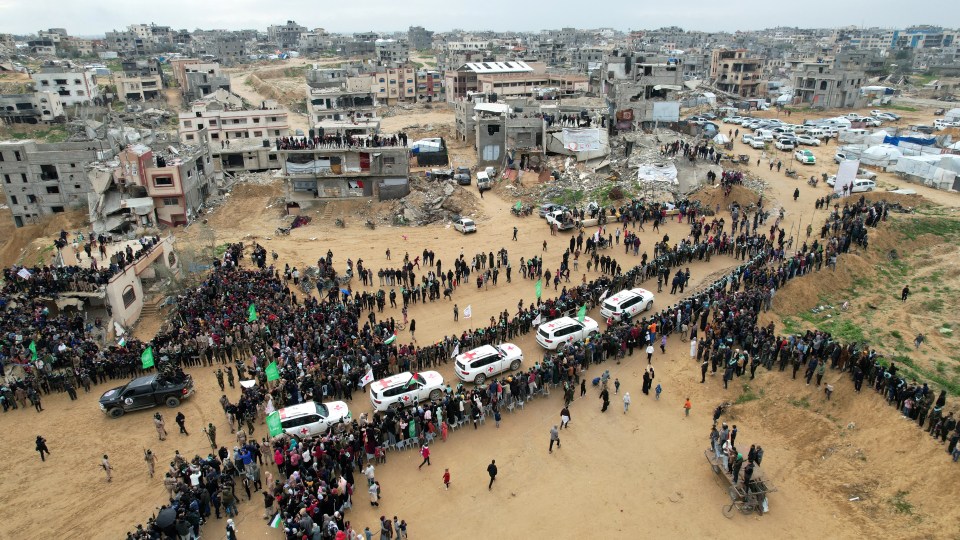 Aerial view of Palestinians and militants near Red Cross vehicles during a hostage exchange.