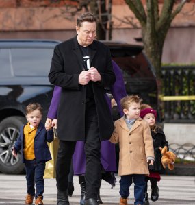 Elon Musk leaving a meeting with three children.