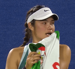 Emma Raducanu wiping sweat with a towel.