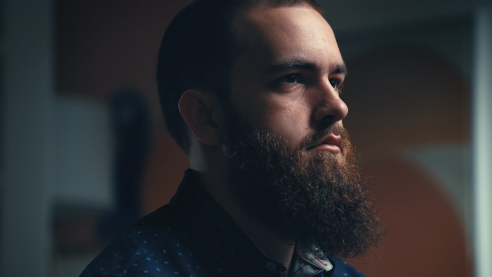 Close-up of a man with a beard, looking to the side.