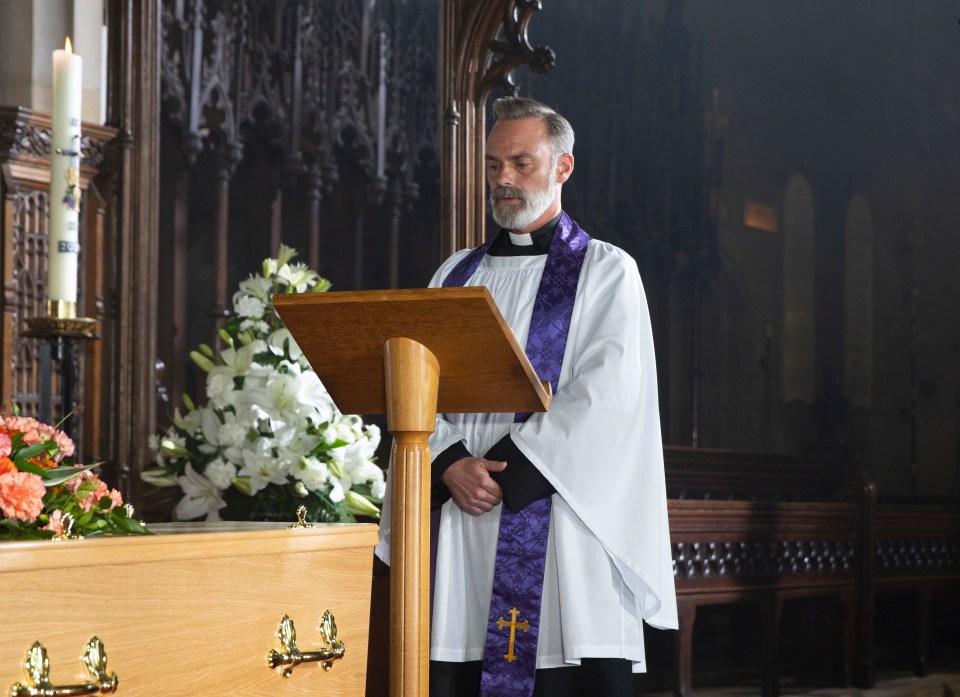 A priest conducting a funeral service in a church.