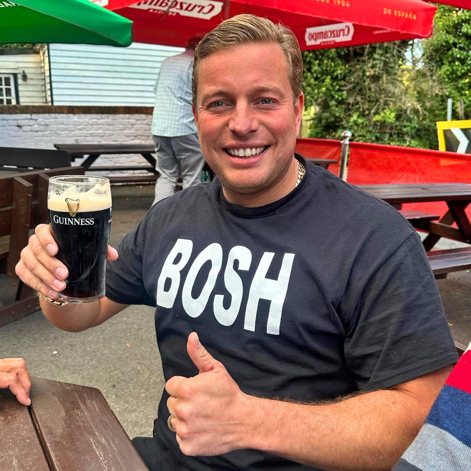 Man holding a pint of Guinness and giving a thumbs up.
