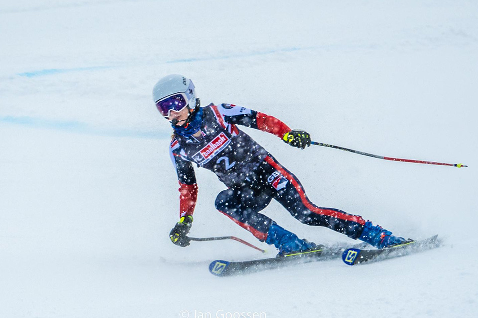 A skier in a GB uniform skiing down a snowy slope.