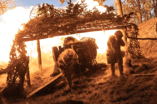 Soldiers firing a howitzer.