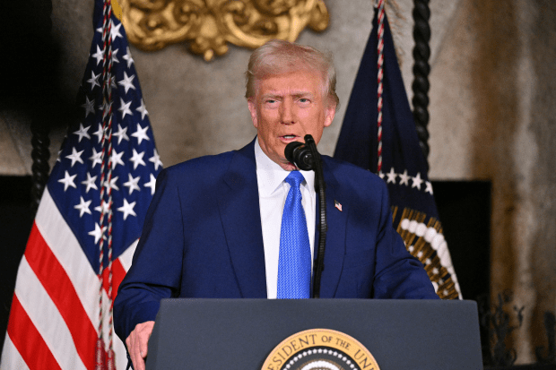 Donald Trump speaking at a podium.