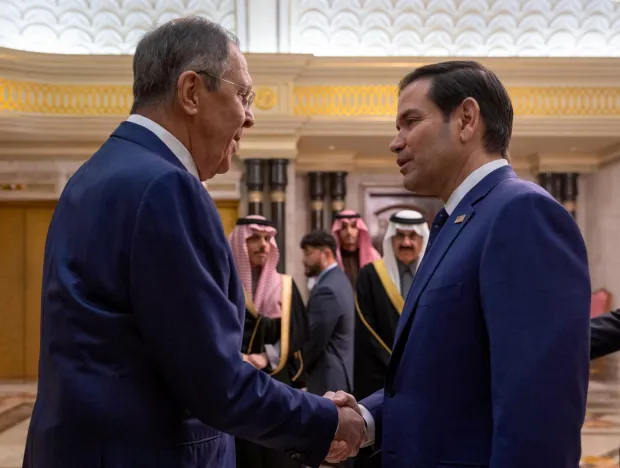 Two men in suits shaking hands.