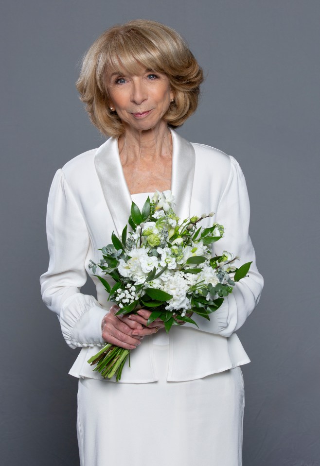 Woman in white wedding outfit holding bouquet.