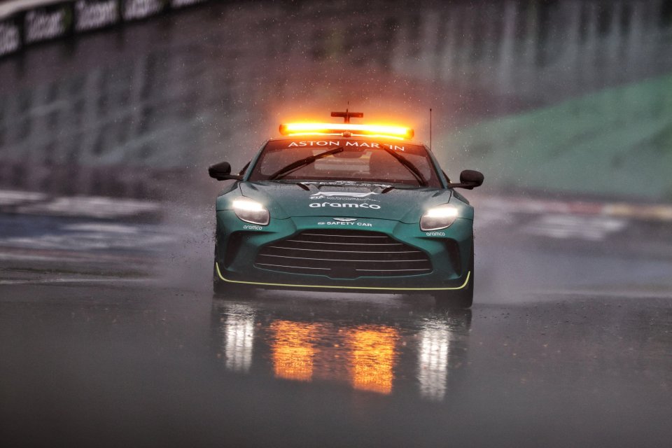 Aston Martin FIA Safety Car on a rain-soaked racetrack.