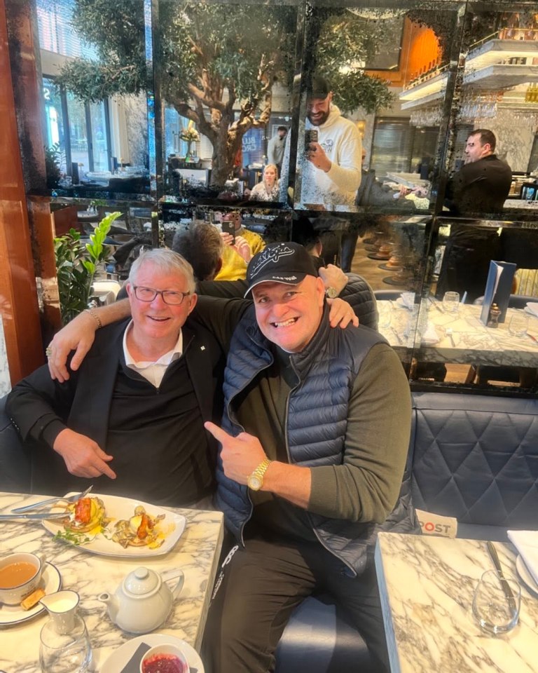 John Fury and Sir Alex Ferguson sitting together at a restaurant.