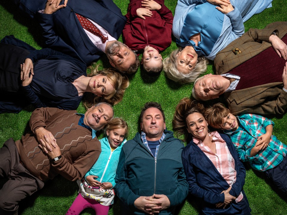 Cast photo of Not Going Out, lying on the grass in a circle.