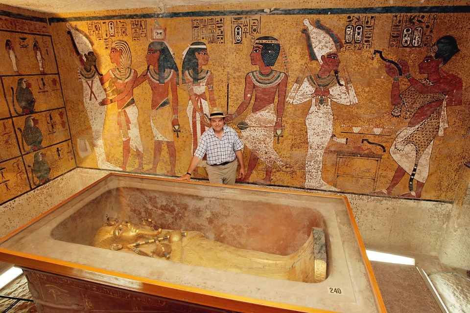 Lord Carnarvon in Tutankhamun's tomb, standing before the sarcophagus.