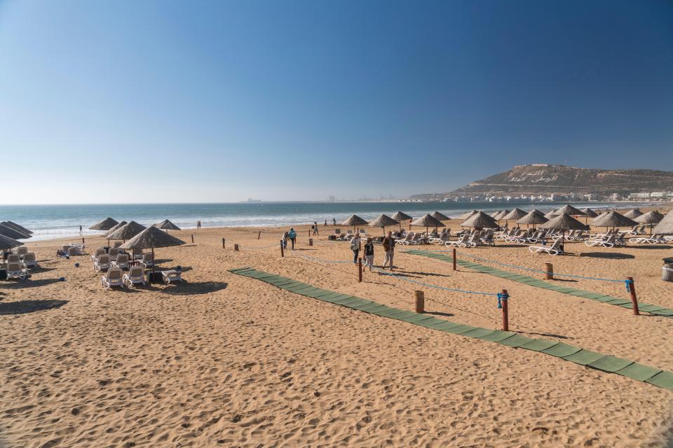 Agadir beach in Morocco with umbrellas and lounge chairs.
