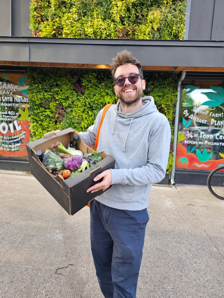 Man holding a box of vegetables.
