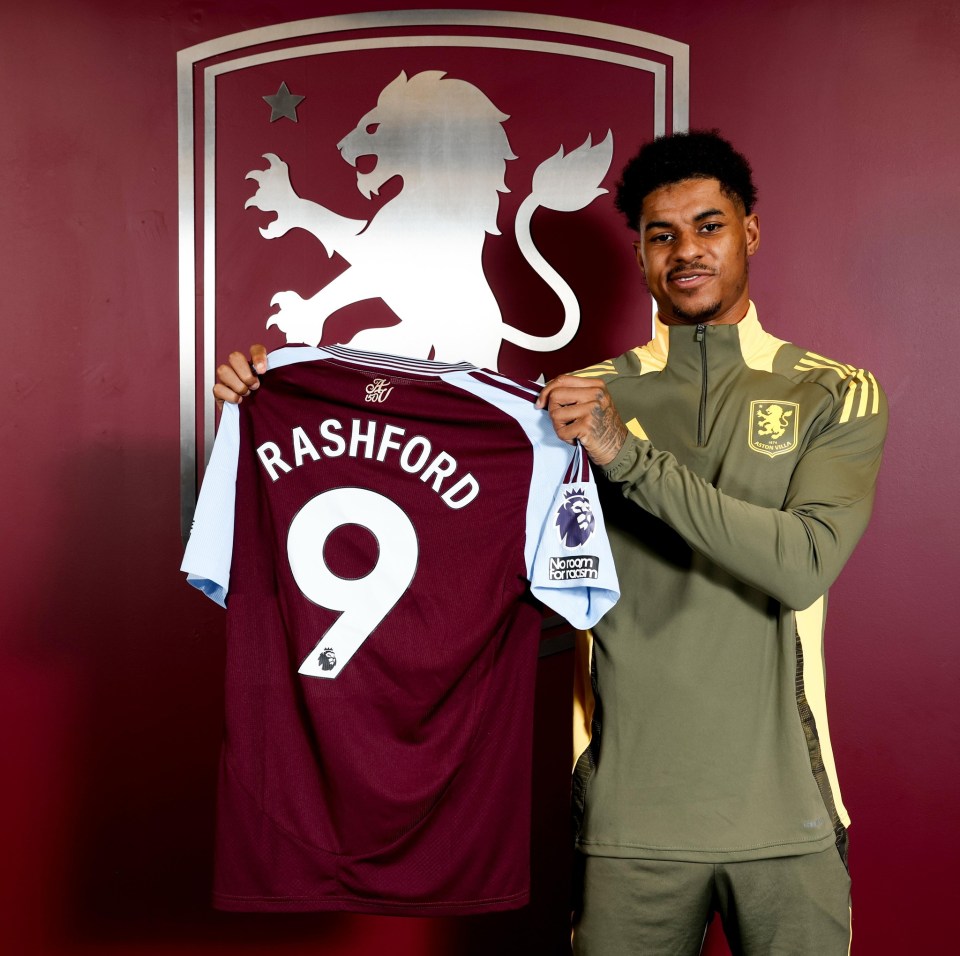 Marcus Rashford holding up his new Aston Villa jersey.