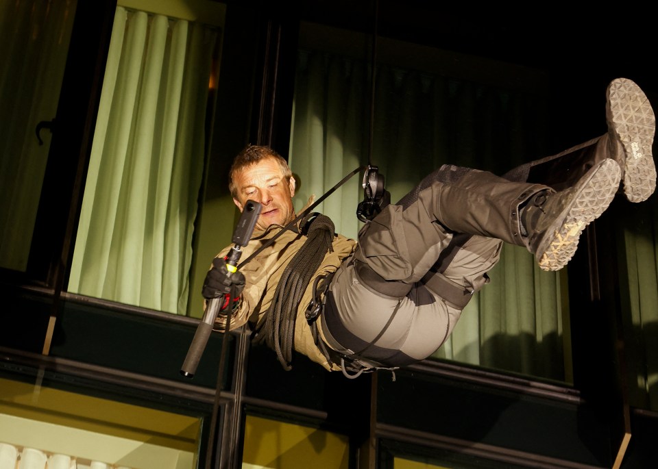 Bear Grylls rappelling down a building.