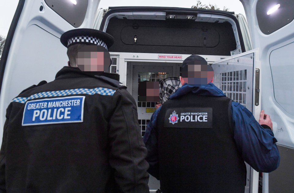 Police officers placing a suspect in a police van.