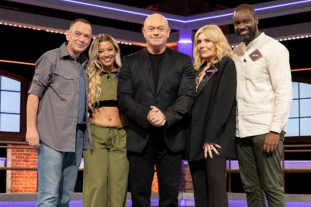 Five judges posing for a photo on a game show set.