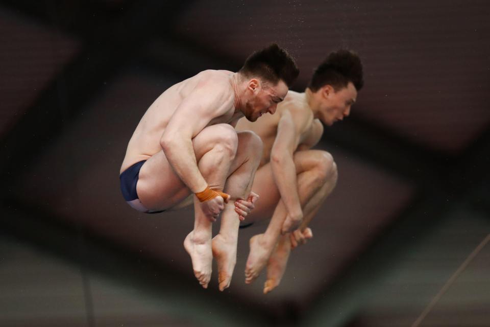 Two divers in midair during a competition.