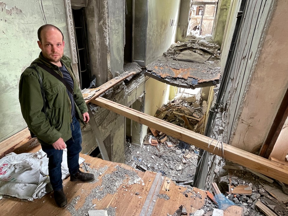 A man stands in a bombed-out building in Kharkiv, Ukraine.