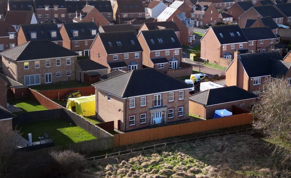 Aerial view of a crime scene at a residential house with police tents.