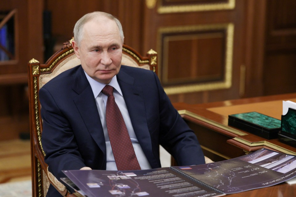 Vladimir Putin reviewing documents.