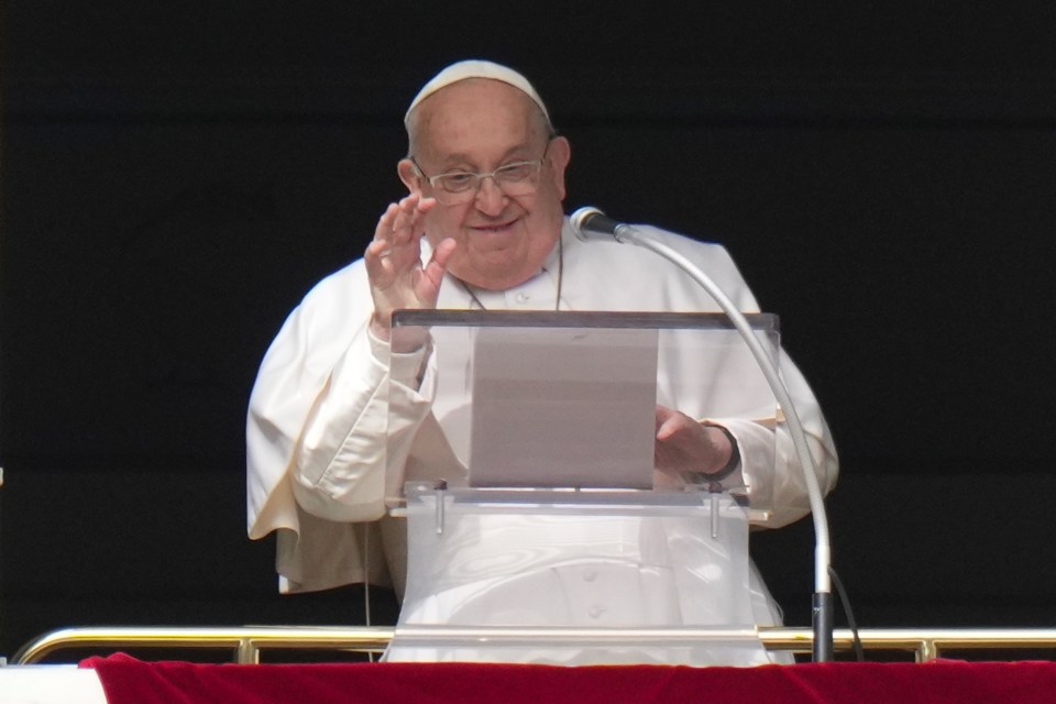Pope Francis giving a blessing from a window.
