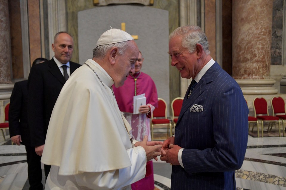 Pope Francis and Prince Charles shaking hands.