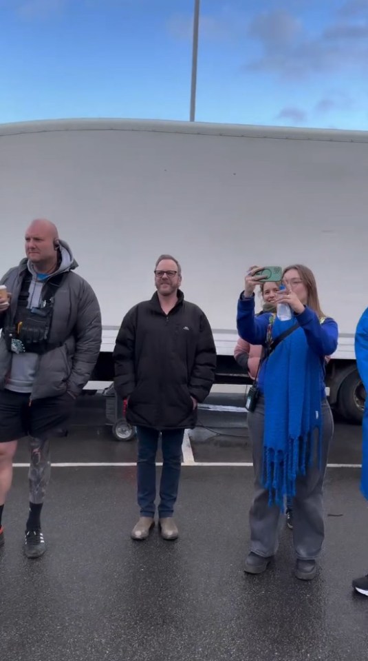 Photo of four people standing outside.