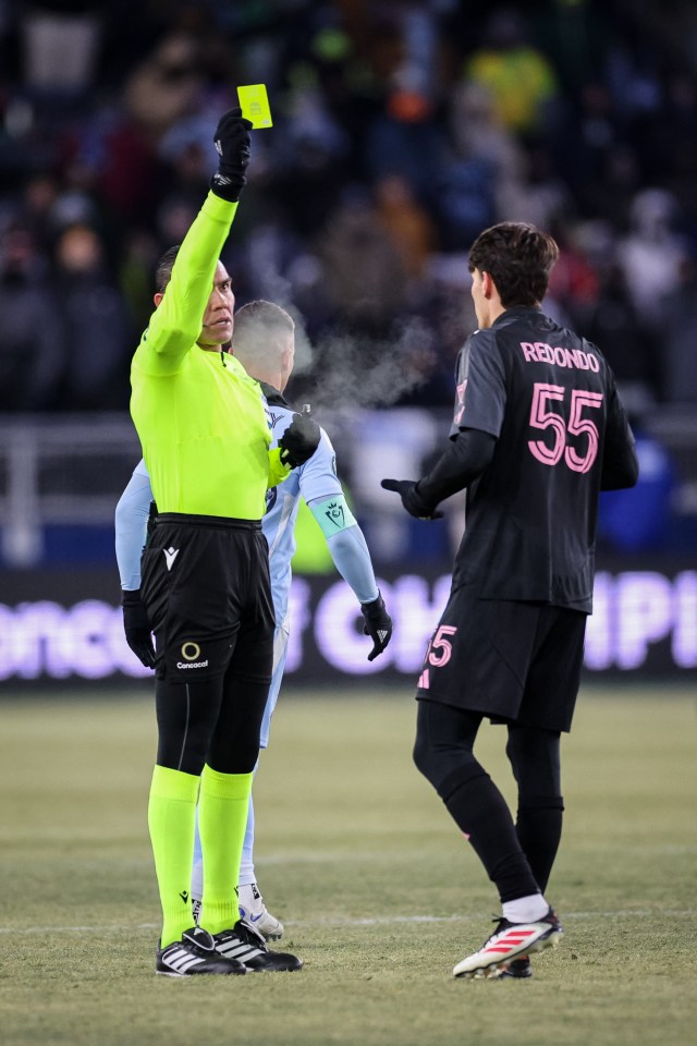 Referee showing a yellow card to a soccer player.