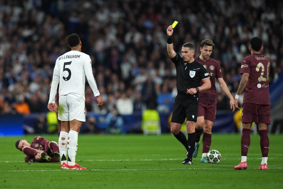 Referee showing Jude Bellingham a yellow card.