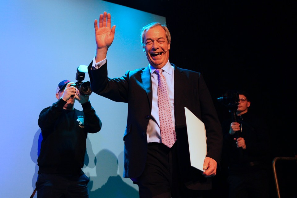 Nigel Farage waving at a conference.